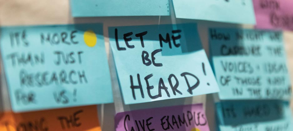A wall of sticky notes, with the central focused note stating LET ME BE HEARD!