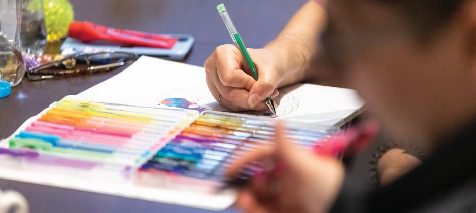 A person colouring in a geometrical pattern.