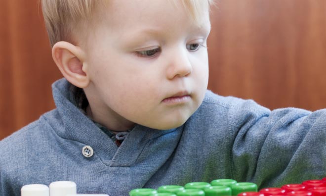 A young child plays with blocks