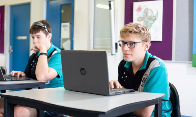 Teens in school uniform using laptops