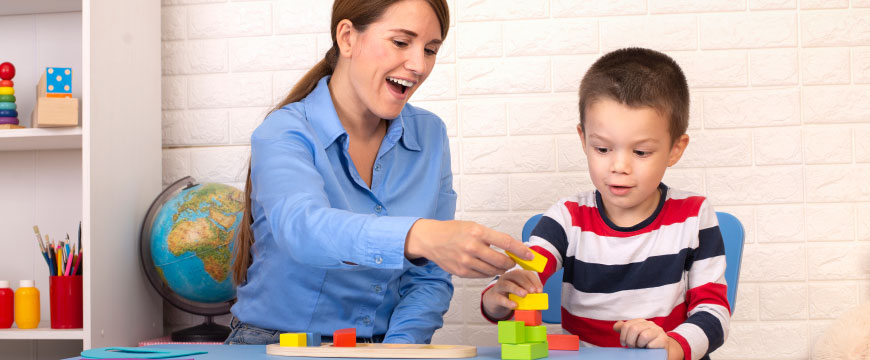 A professional and a small child playing with blocks
