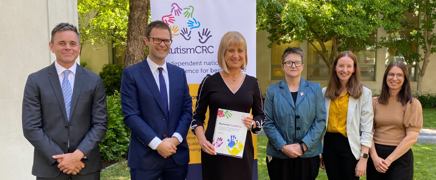 The Guideline Development Group, who wrote the Supporting Autistic Children Guideline, and the Hon. Justine Elliot. Justine Elliot holds a copy of the Guideline.