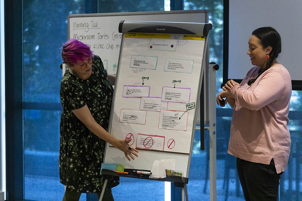 Two people organising text on a board