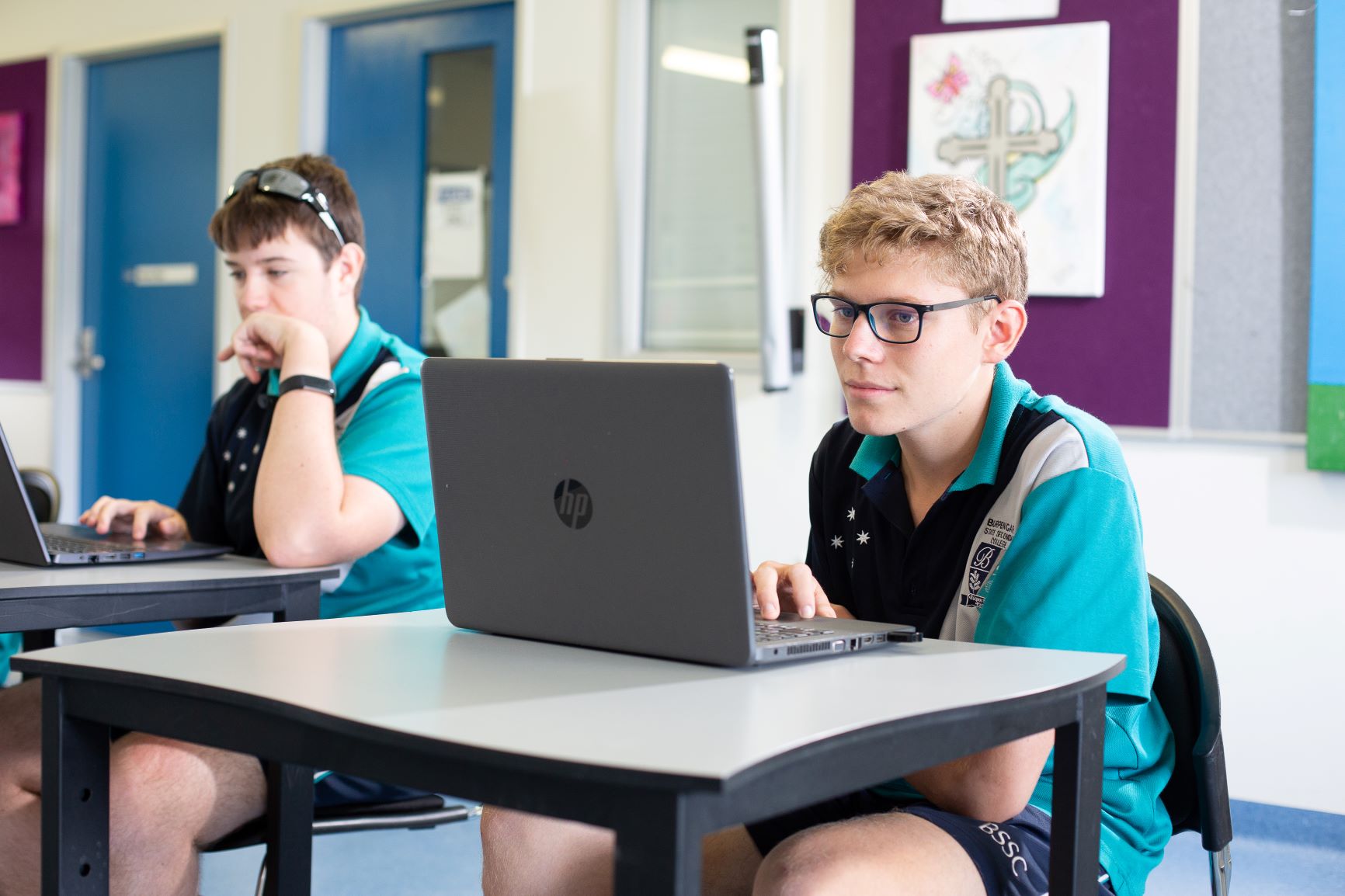 Students in school uniform are focused on using computers