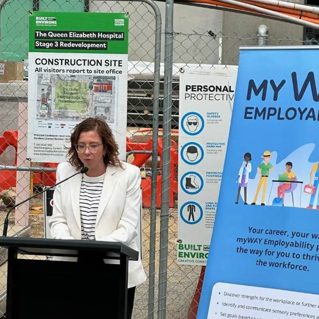 Hon Amanda Rishworth speaks into a microphone, behind her is a construction fence and a promotional banner for myWAY Employability